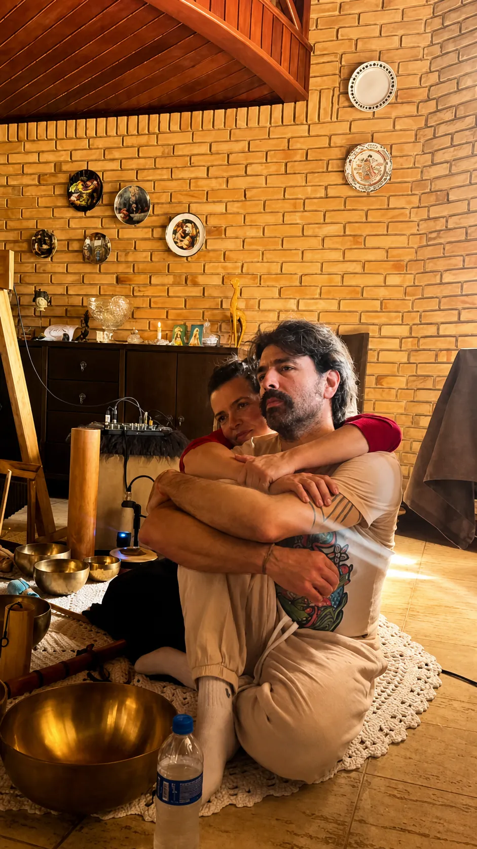 Rafa e Zeca em um abraço cercados por tigelas tibetanas